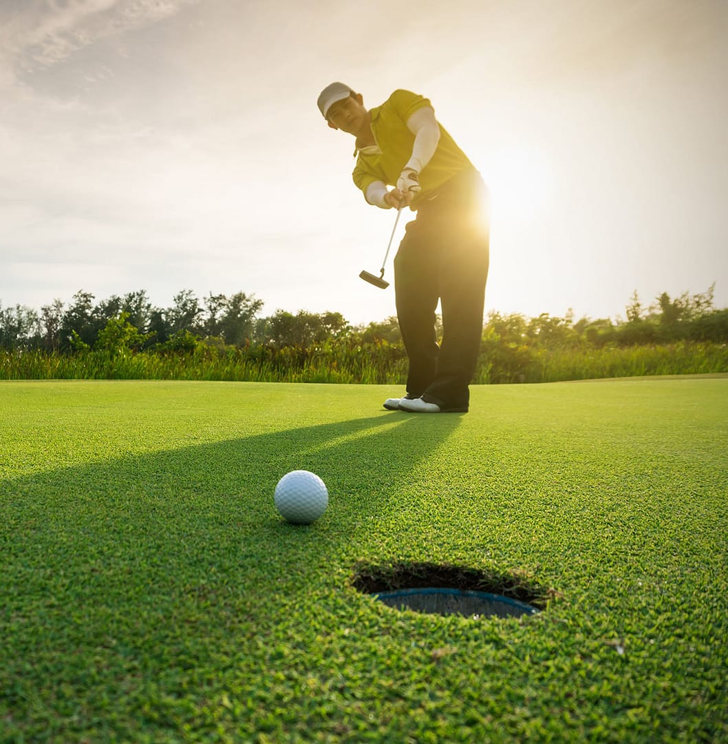 golfer putting a ball into the hole